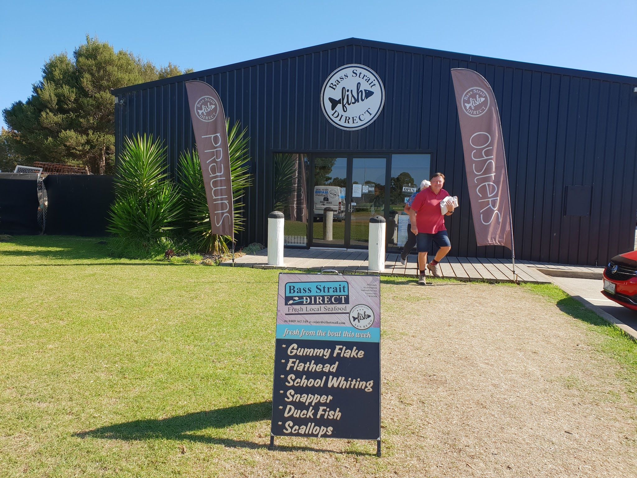 Bass Strait Direct seafood shop exterior on a sunny day with signage banners